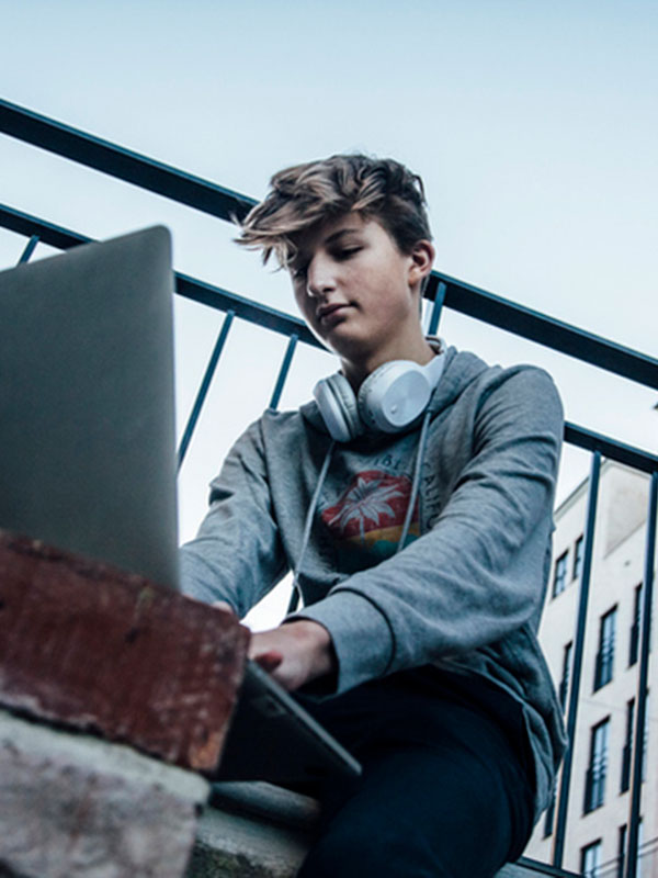 teenage boy working from laptop
